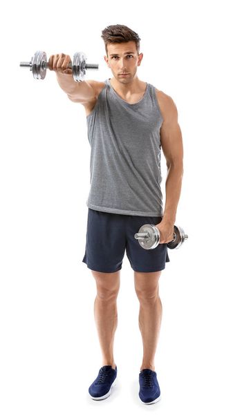 Sporty young man with dumbbells on white background - Fotoğraf, Görsel