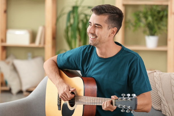 przystojny mężczyzna gra na gitarze w domu - Zdjęcie, obraz