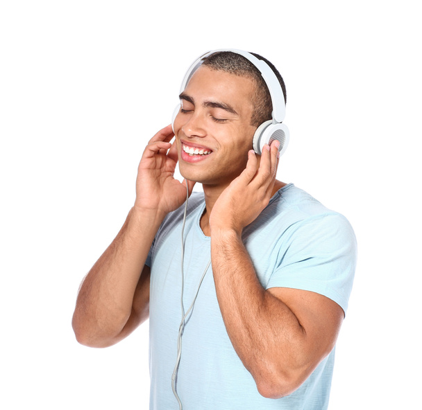 Portrait of handsome young man listening to music on white background - Fotoğraf, Görsel