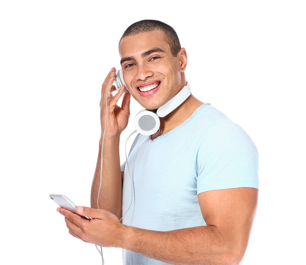Portrait of handsome young man listening to music on white background - Photo, Image
