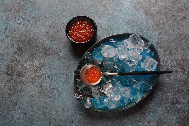 Delicious red caviar in a bowl with ice cubes - Foto, Bild