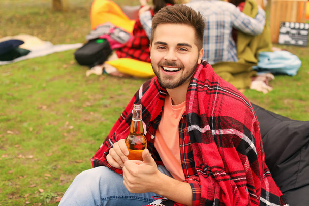 Felice giovane uomo con bottiglia di birra nel cinema all'aperto
 - Foto, immagini