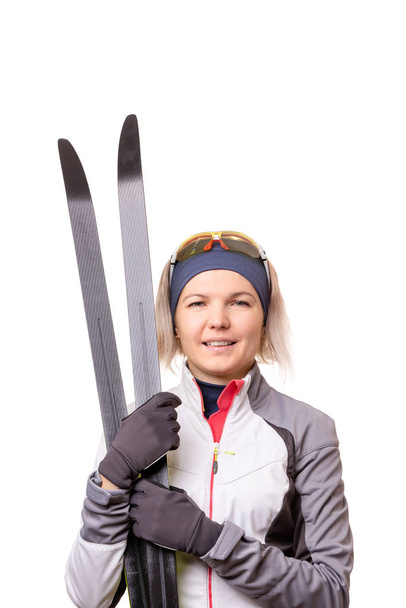 Foto de una joven deportista con esquís sobre fondo blanco vacío
. - Foto, imagen