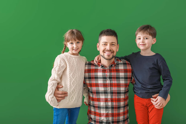 Щаслива сім'я в зимовому одязі на кольоровому фоні
 - Фото, зображення