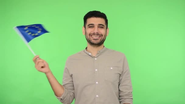 European Union flag. Portrait of happy brunette man holding EU f - Materiaali, video