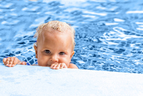 Baby in swimming pool, view from top, toned in blue - Foto, Imagem