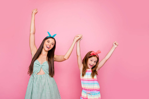 Portrait of cheerful two women holding hands wearing headbands dress skirt isolated over pink background - Foto, immagini