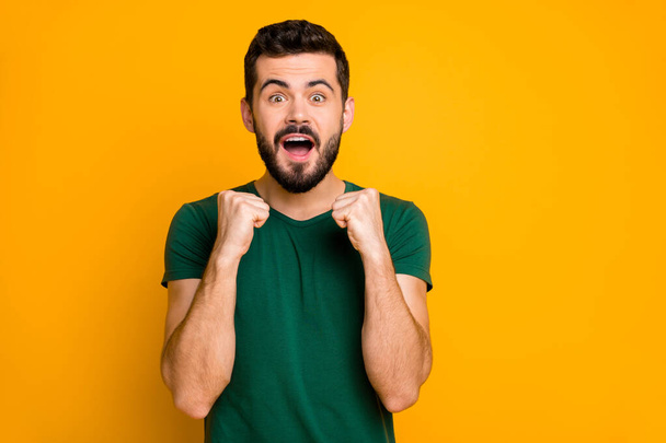 Portrait of excited astonished guy follow his favorite sport team stare they win scream wow omg raise fists feel rejoice wear modern clothes isolated over yellow color background - Fotó, kép