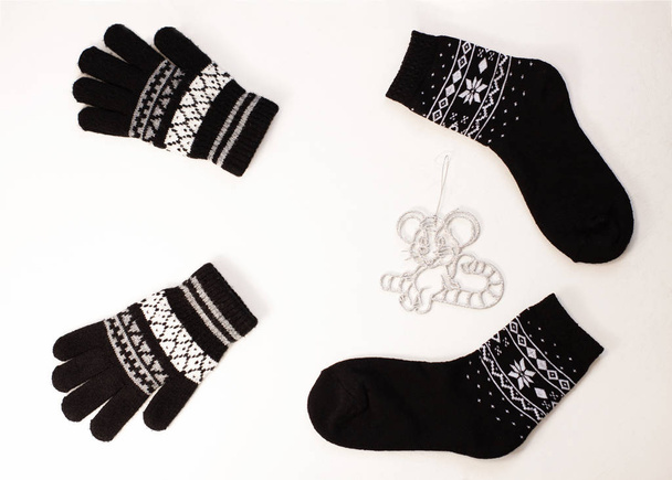 New year 2020 flat lay.Christmas black ornamental socks,gloves, silver rat toy on lollipop candy.Winter holidays concept - 写真・画像