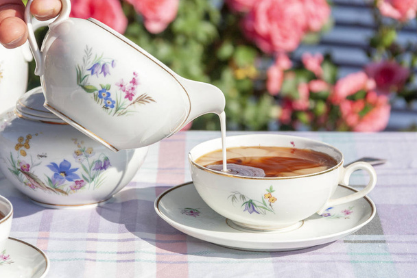 Herbata w angielskim stylu na tle róż - Zdjęcie, obraz