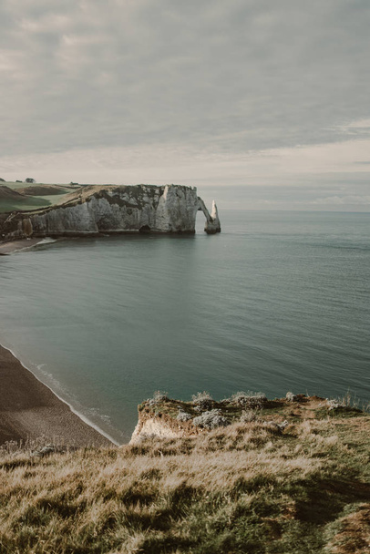 coastal landscape along the Falaise d'Aval the famous white cliffs of Etretat village with the Porte d'Aval natural arch and the rock known as the Aiguille d'Etretat - Foto, immagini