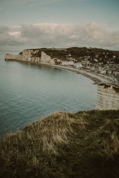 coastal landscape along the Falaise d'Aval the famous white cliffs of Etretat village with the Porte d'Aval natural arch and the rock known as the Aiguille d'Etretat - Foto, immagini