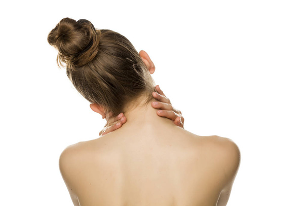 Giovane donna stanca tocca il collo su sfondo bianco
 - Foto, immagini