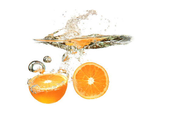 Two Orange fruits dropped into water splash on white background - Фото, изображение