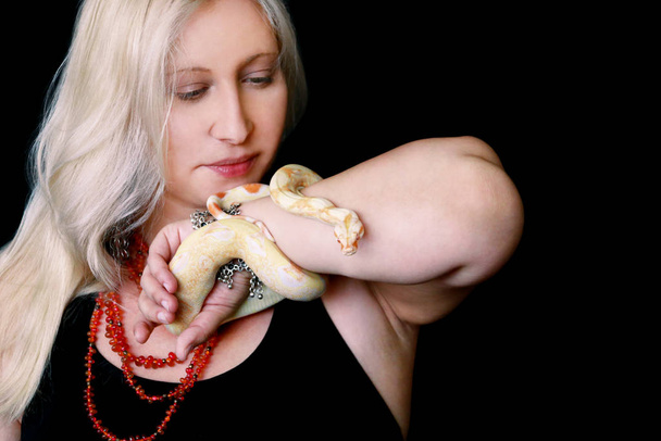 Portrét dívky s boa constrictor albino hadem. Žena drží hada v rukou s krásnými šperky a pózuje před kamerou. Exotické Boa constrictor nejedovaté druhy hada. Koncept mazlíčků. - Fotografie, Obrázek