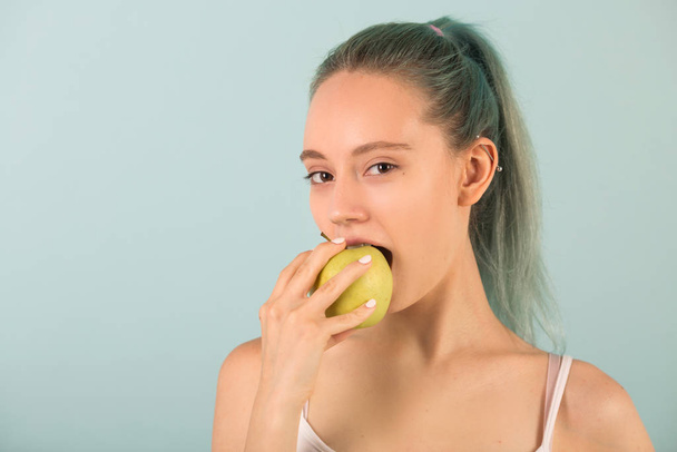 beautiful slim young woman in sportswear with an apple in her hand - Photo, Image