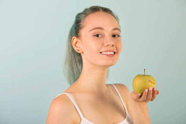 kaunis hoikka nuori nainen urheiluvaatteet omena kädessään
 - Valokuva, kuva