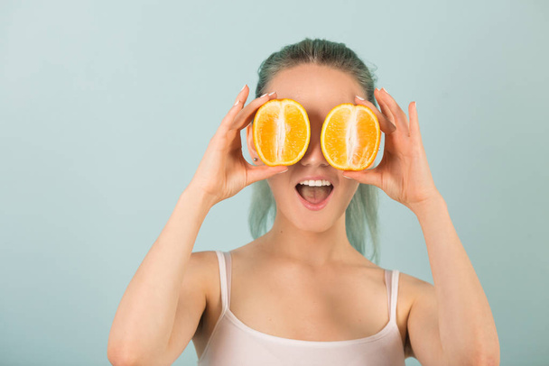 beautiful slender young woman in sportswear with oranges in her hands - Fotó, kép
