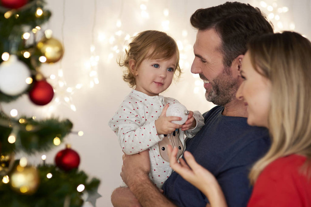 Pais com bebê decoração árvore de Natal
 - Foto, Imagem