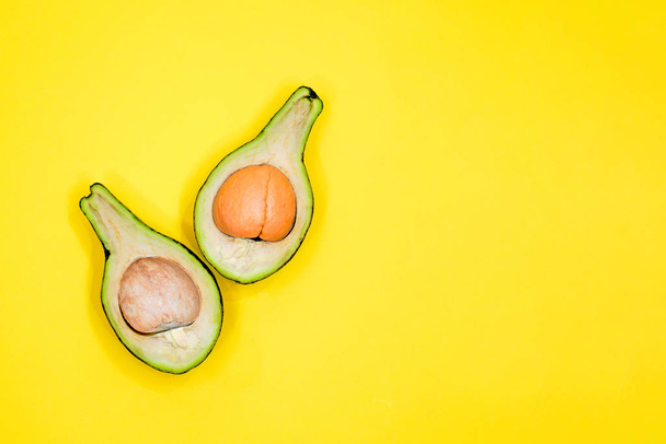 Ripe avocado on yellow background top view. Creative food compos - Foto, Imagen