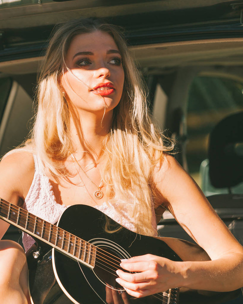 Girl with guitar on hatchback car - 写真・画像