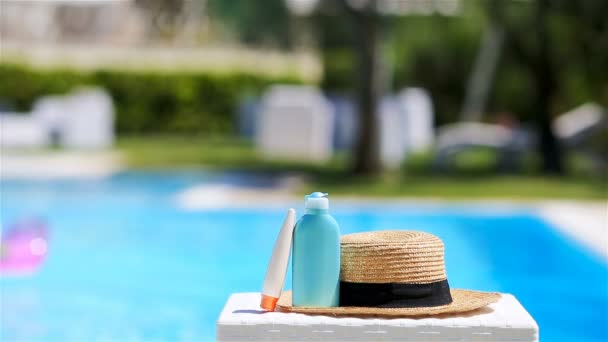 Suncream, καπέλο, γυαλιά ηλίου κοντά στην πισίνα - Πλάνα, βίντεο