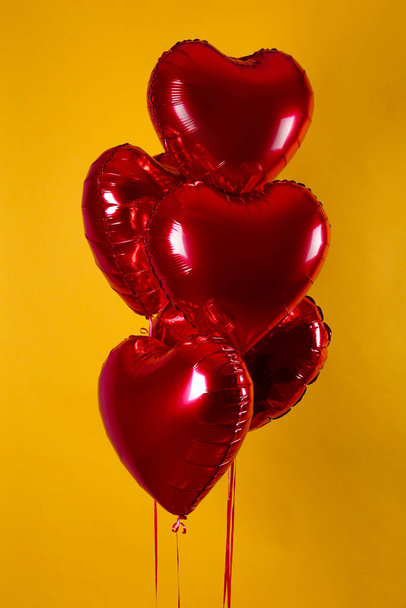 Heart shaped helium inflated red foil air balloon flying in the air. - Фото, зображення