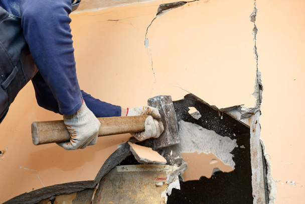 Der Bauhammer bricht alte Trennwände in der Wohnung - Foto, Bild