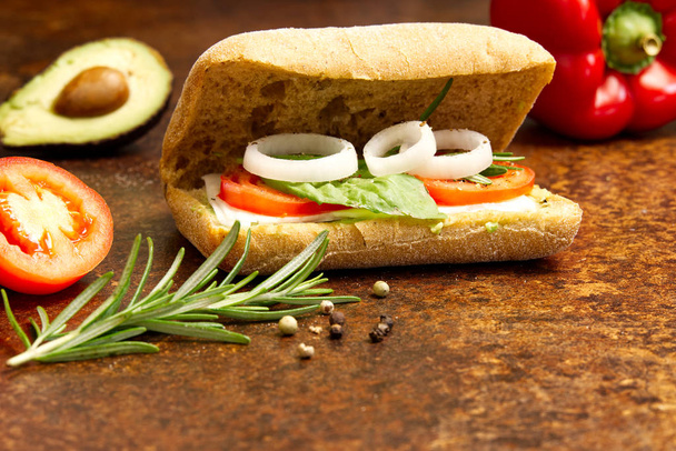 Ciabatta italien et ingrédients sandwich. oignon, tomate, poivre, fromage de chèvre, razmoin, basilic et avocat. Photographie
 - Photo, image