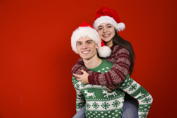 Couple of young people wearing ugly christmas sweaters, posing over colorful isolated background. - Foto, Bild