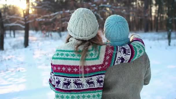 Családi ölelés téli erdőben dobált hó és élvezi a táj. Anya és lánya jól érzik magukat a szabadban. Szezonális tevékenységek. - Felvétel, videó
