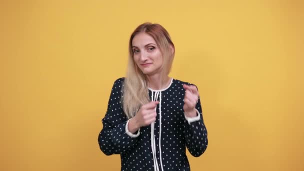 Aantrekkelijke Kaukasische jongedame kijkt naar camera, houdt vuisten omhoog, vechten - Video