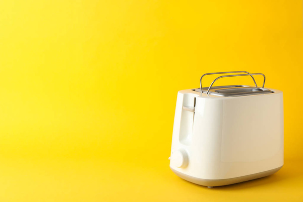 Sarı arkaplanda ekmek kızartma makinesi, metin için boşluk - Fotoğraf, Görsel