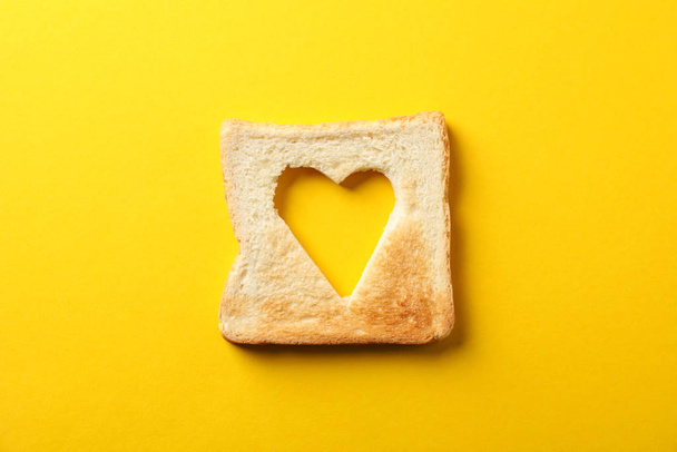 黄色の背景にハートの形をしたトーストパン、トップビュー - 写真・画像