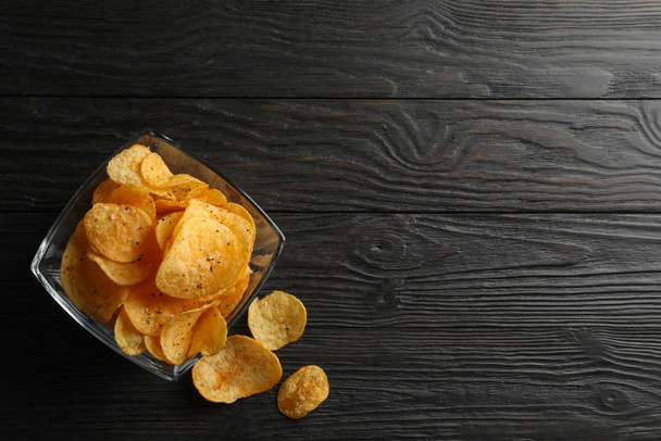 Potato chips in a place on wooden background, space for text. To - Fotó, kép
