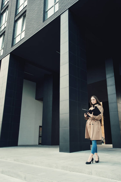Self-confidence young business woman with file in a hand. outdoor. cityscape - Photo, Image