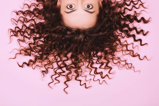 Big beautiful eyes of suprising young woman on pink background. - Foto, afbeelding