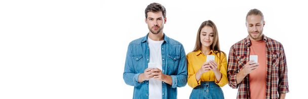 smiling three young friends using smartphones isolated on white, panoramic shot - Fotó, kép