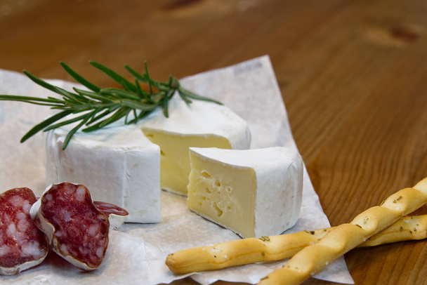 Kaas voorgerecht selectie of kaas en wijn feesttafel. Brie kaas, brood stokjes en salami is geweldig voorgerecht om uw diner te beginnen. - Foto, afbeelding