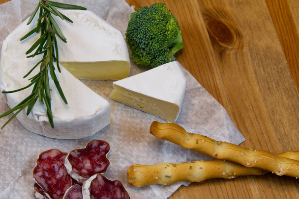 Kaas voorgerecht selectie of kaas en wijn feesttafel. Brie kaas, brood stokjes en salami is geweldig voorgerecht om uw diner te beginnen. - Foto, afbeelding