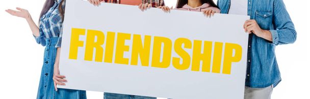 Beyaz, panoramik bir karede izole edilmiş sarı dostluk harfleriyle pankart tutan arkadaşlar. - Fotoğraf, Görsel