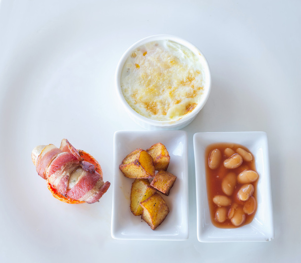 Омлет, яичница со свиной колбасой и беконом на белой тарелке
 - Фото, изображение