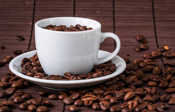 Kaffeetasse und eine Streuung von Kaffeebohnen - Foto, Bild