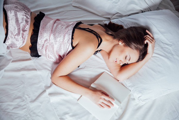 девушка в розовом пижаме лежит на кровати
 - Фото, изображение