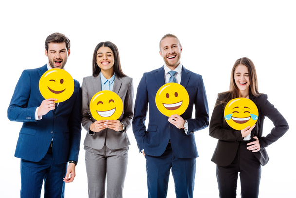 KYIV, UKRAINE - AUGUST 12, 2019: multicultural business people in suits holding smileys isolated on white - Foto, immagini