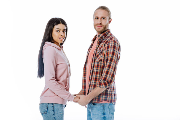 smiling young interracial couple holding hands isolated on white - Photo, image
