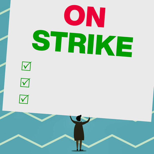 Handwriting text writing On Strike. Concept meaning refuse to continue working because of an argument with an employer Man stands in back view under huge empty blank big tilted rectangle board. - Photo, Image