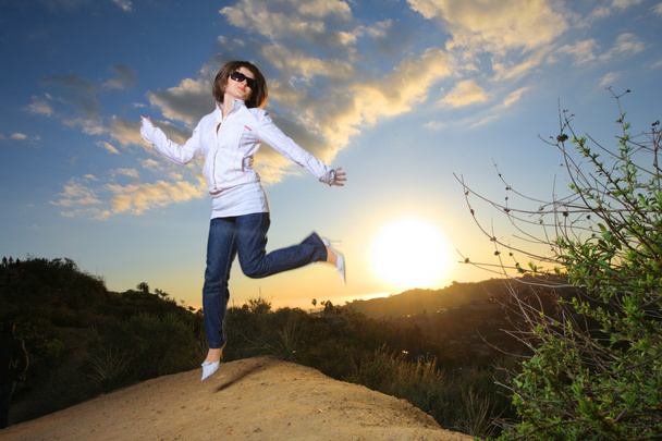 Joyeux jeune femme sautant dans le parc au coucher du soleil
 - Photo, image
