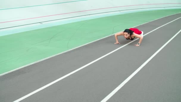Fitness vrouw doet push-ups op de rails. Sportief meisje doet push-ups oefening - Video