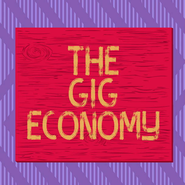 Tekstikyltti, jossa näkyy The Gig Economy. Käsitteellinen kuva Market lyhytaikaisten sopimusten freelance työtä tilapäinen neliö suorakulmio epätodellinen sarjakuva puu puinen naulattu juuttunut värillinen seinä
. - Valokuva, kuva